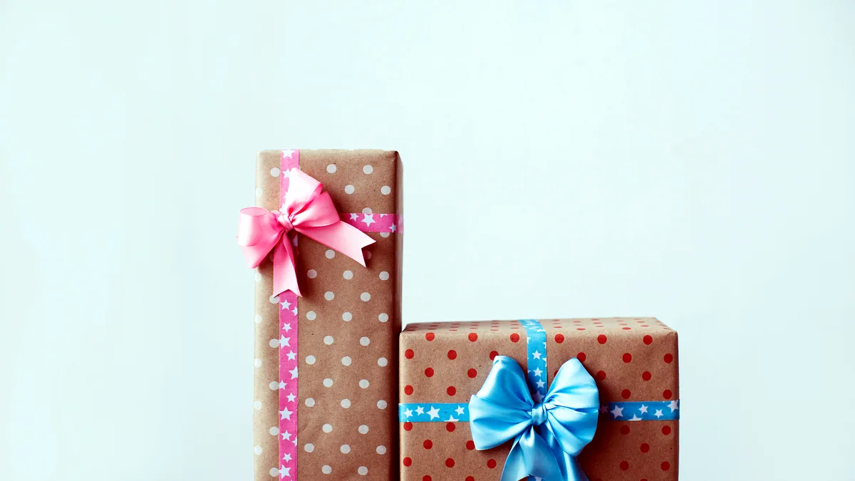 Neatly wrapped gift boxes tied with cream ribbons on a linen tablecloth.